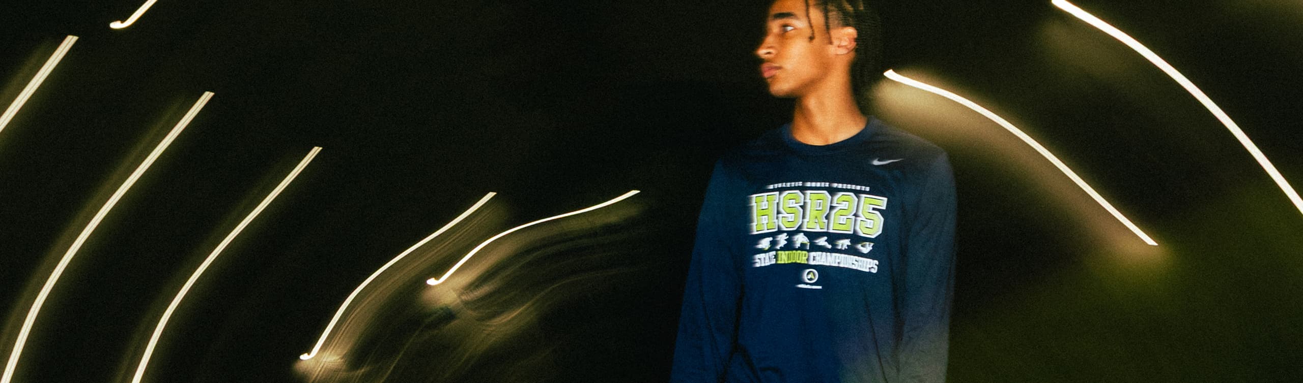 Wide Receiver looking off to the side with a long-exposure style background of streaked lighting