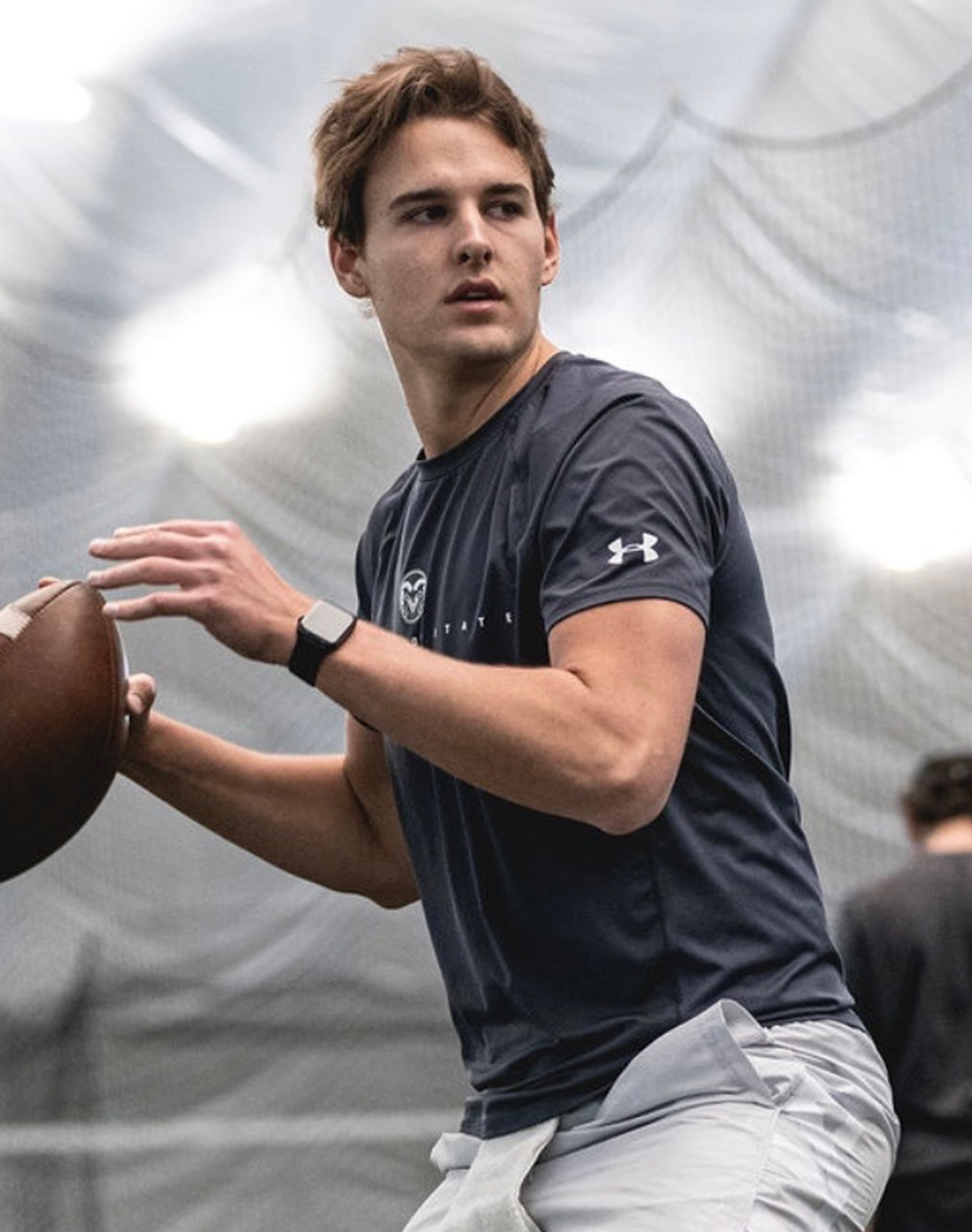 Coach Jarred Park critiquing a quarterback at a training session
